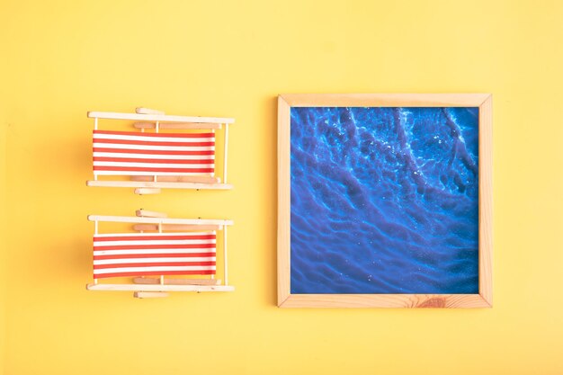 Photo two folding beach chairs and a pool with water on a yellow background the atmosphere of summer recreation by the pool minimalism