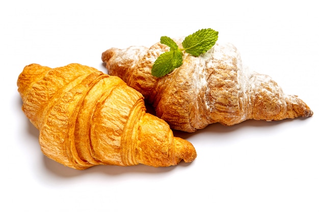 Two fresh croissants on white background