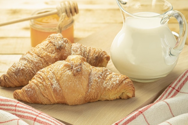 Two fresh croissants on a wooden rustic background