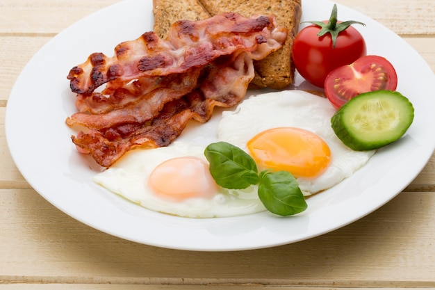 健康的な朝食の選択的な焦点のための2つの目玉焼きとベーコン