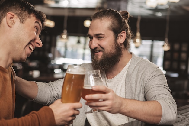 Due amici che chiacchierano davanti alla birra al pub