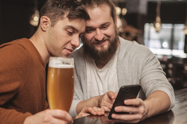 Two friends having chatting over beer at the pub