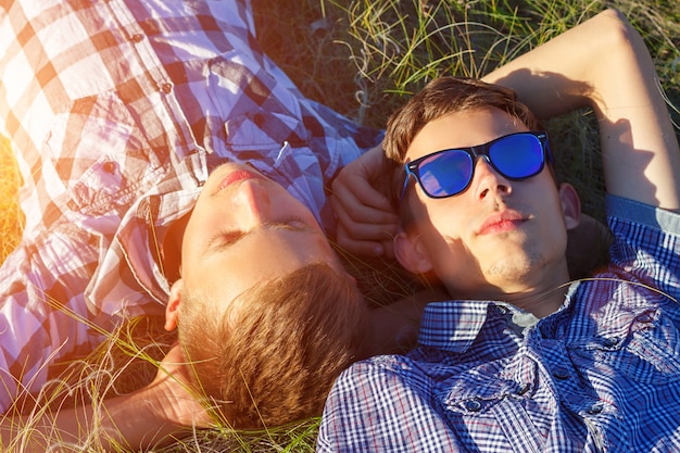 Two friends lie on the grass