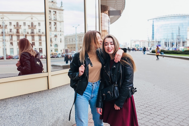 Two friends meeting in the street of the city and hugging . friendship, happiness concept . Couple of woman