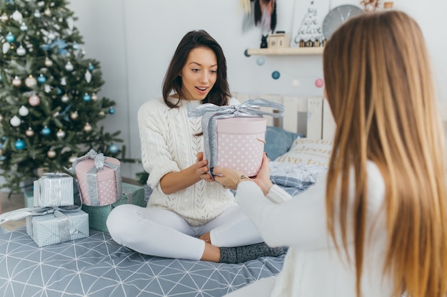 2人の友人がクリスマスプレゼントを開きます。