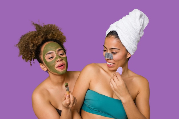 Two friends pamper themselves with facial treatments for a relaxing spa day at home