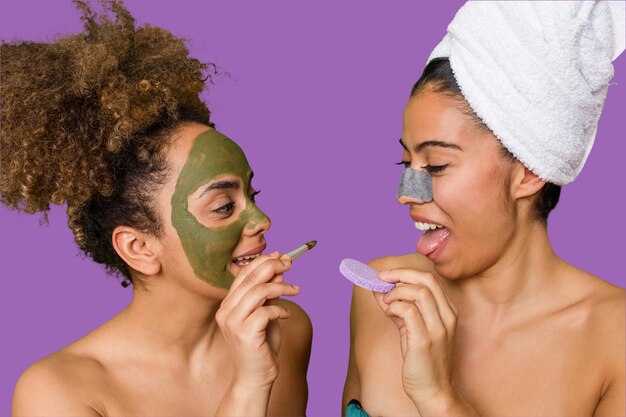Two friends pamper themselves with facial treatments for a relaxing spa day at home