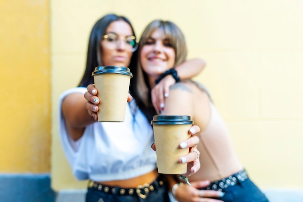 リラックスしてコーヒーを飲む2人の友人。コーヒーブレイク。行くためにコーヒーを教える。