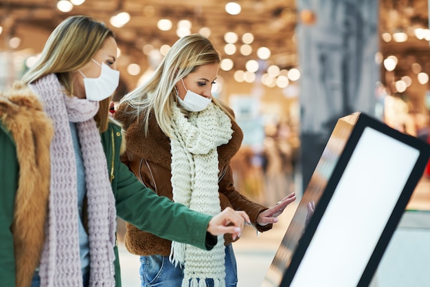 two friends shopping together wearing a mask, coronavirus concept