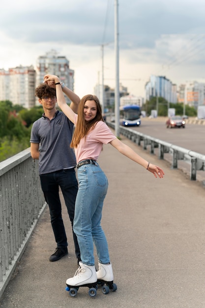 Photo two friends spending time together outdoors using roller skates