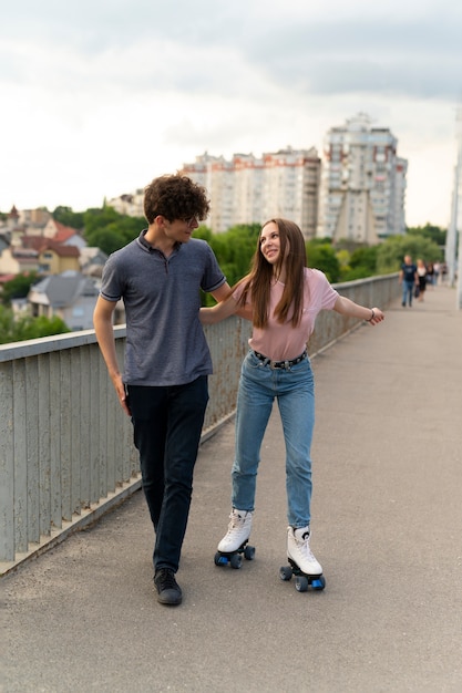 Photo two friends spending time together outdoors using roller skates