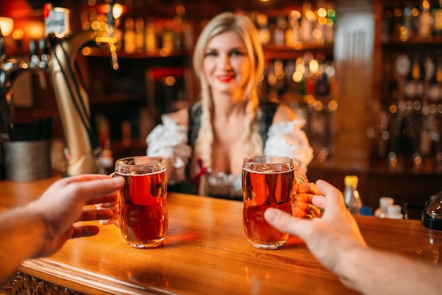 Two friends takes beer from waitress, oktoberfest