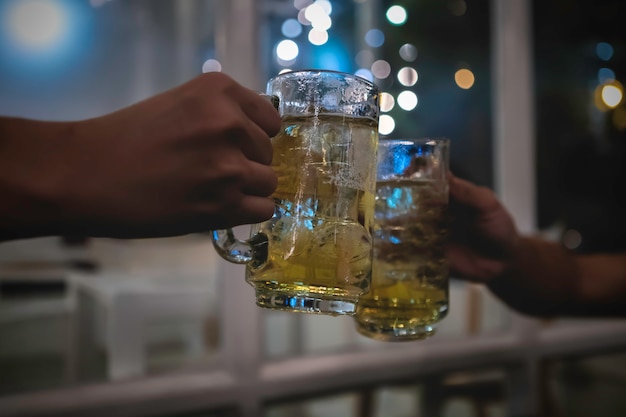 Due amici brindando con bicchieri di birra leggera al pub