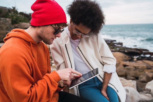 Two friends using digital tablet.