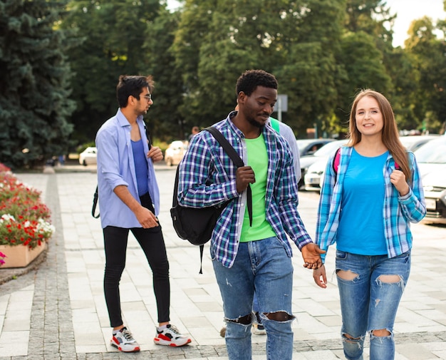 Two friends with backpacks walking and talking outdoors