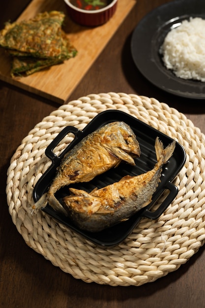 Two Fries Short Mackerels place on a black pan