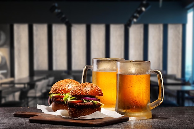 冷ややかな軽めのビール 2 杯とハンバーガー 2 杯