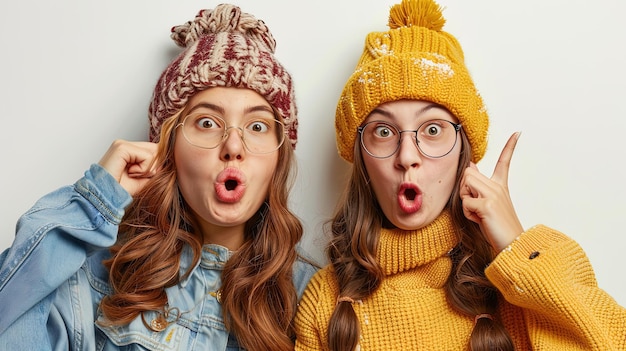 Two funny girls in hats and scarves on a white background