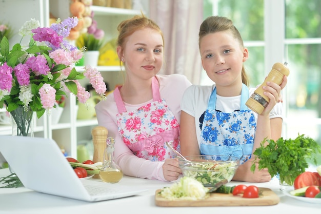 Two funny girls preparing fresh salad