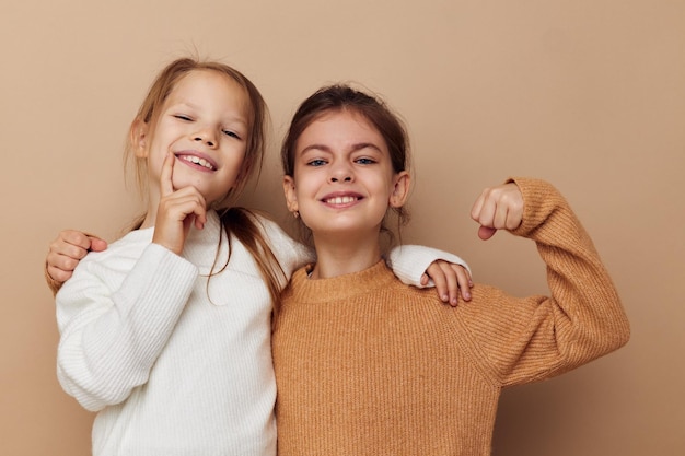 Two funny little girls in sweaters posing childhood