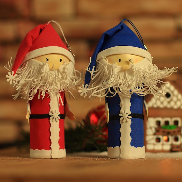 Two funny santa claus on the background of a gingerbread house