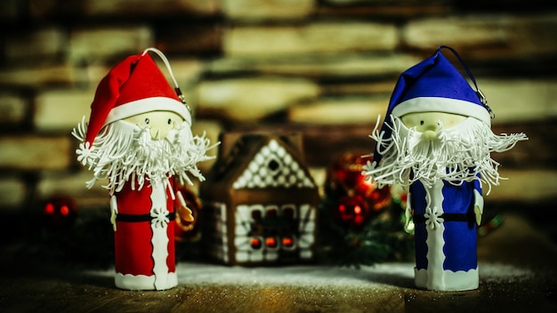 Two funny Santa Claus on the background of a gingerbread house