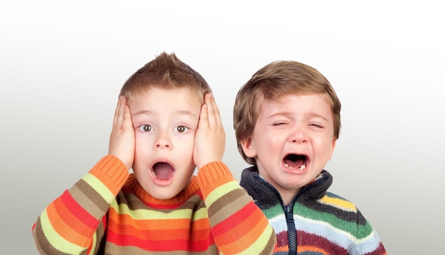 Two funny small brothers showing emotions