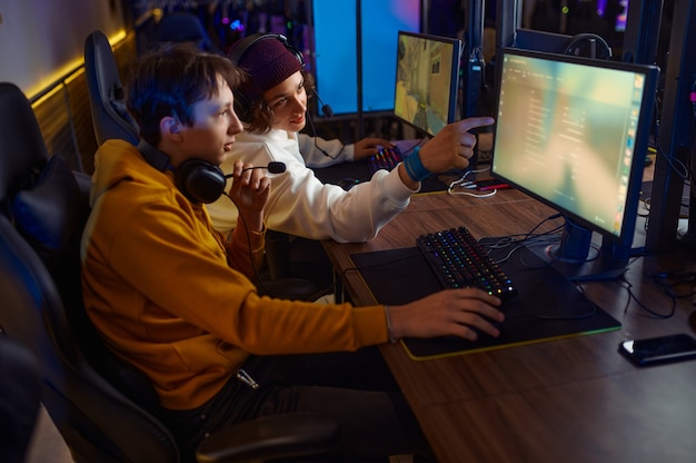 Two gamers in headsets play in game club