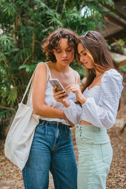 Photo two girl friends are looking at a smart phone