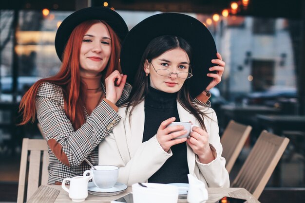 Two girl friends drinking coffee in the cafe