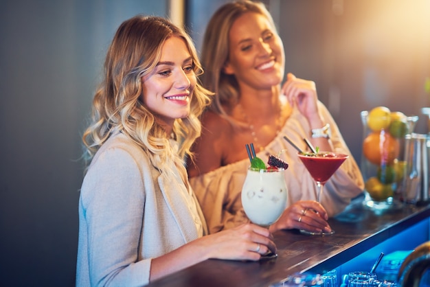 two girl friends having drinks in bar