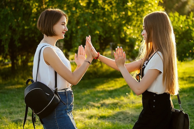 two girl friends meeting in the park