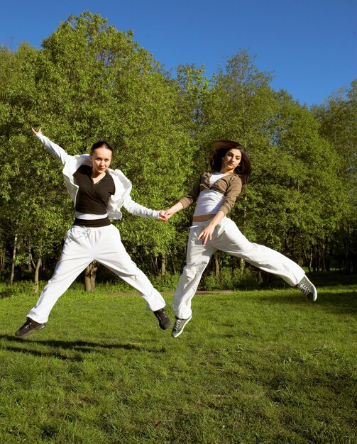 Two girl jumping in park