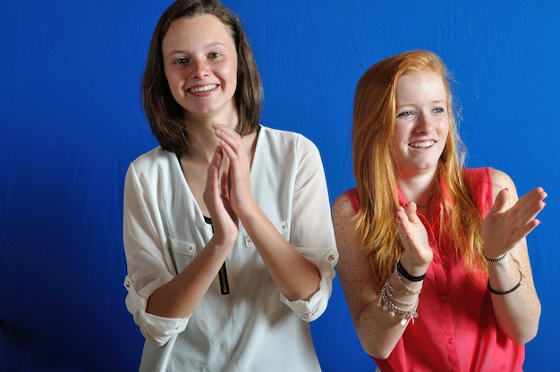 Two girl teens who are applaudissing