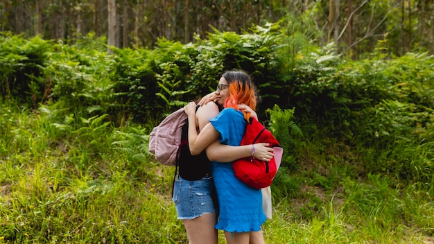 Photo two girlfriends a couple hug each other in love and happily during a walk in nature in the summer