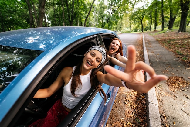 Two girlfriends fool around and laughing together in a car