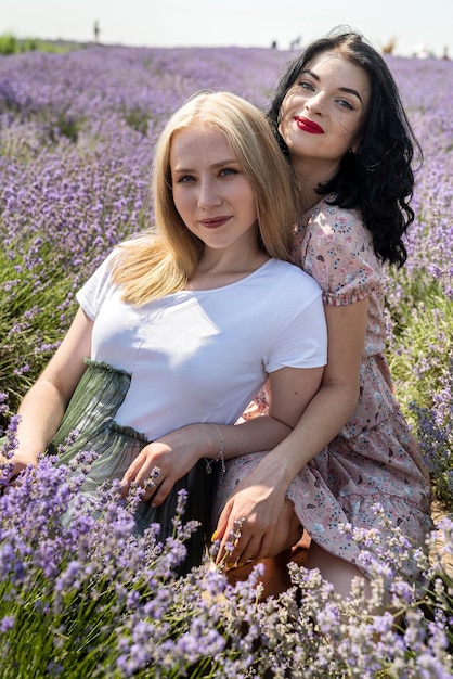 Two girlfriends have a good time on a lavender field summer time