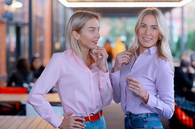 two girlfriends in pink shirts, young adult beautiful models in shirts, casual style