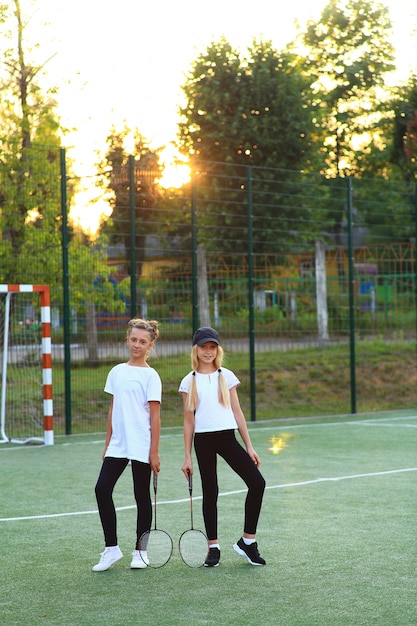 수업을 마치고 두 소녀가 놀이터에서 테니스를 치러갑니다.