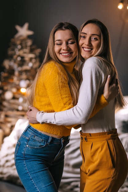 Two girls are hugging in Christmas interior