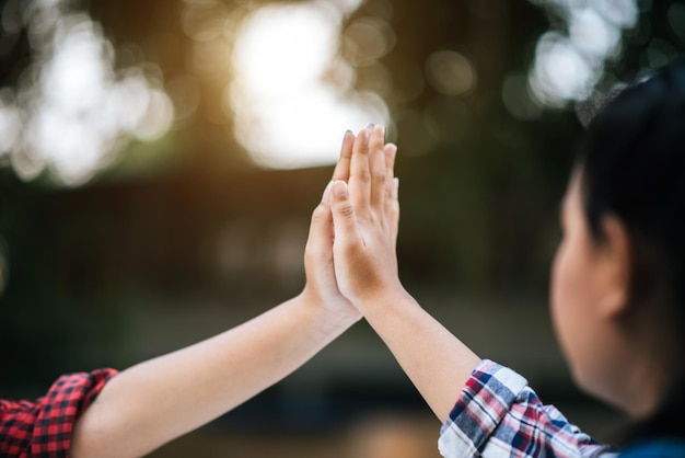 写真 大学生の2人の女の子がハイファイブを祝っています