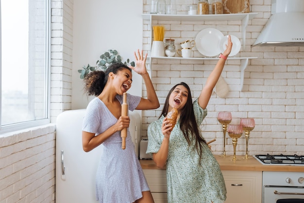 Two girls of different races having fun together in the kitchen