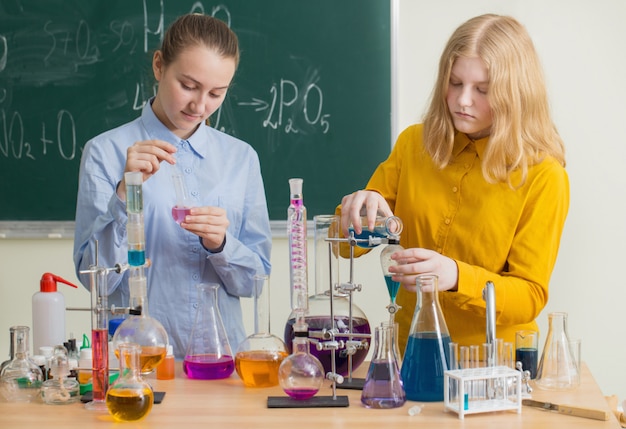 Two girls doing chemical experiments in school