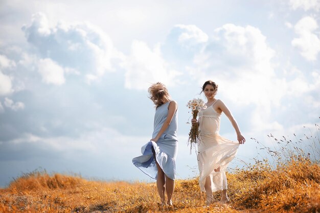 Two girls in dresses in autumn field