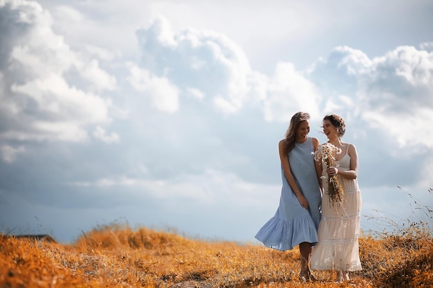 Two girls in dresses in autumn field