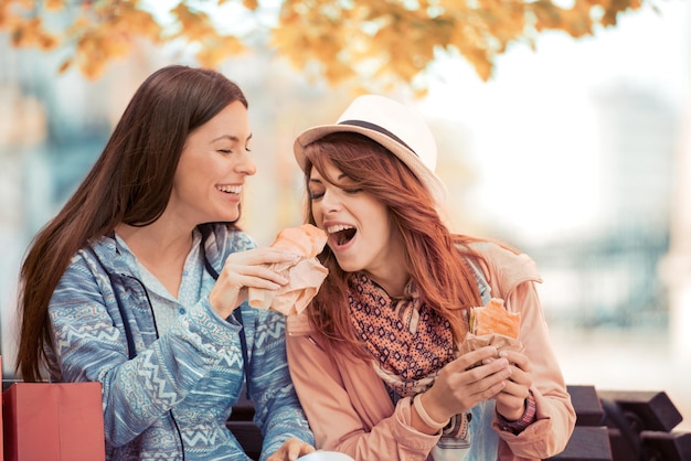 Two girls eating sandwiches