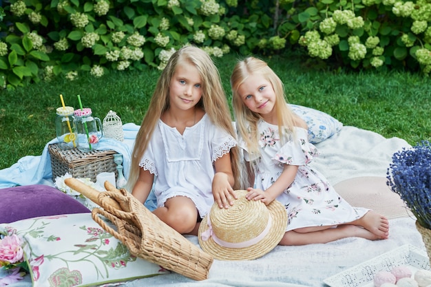 two girls friends in the garden at a picnic in the summer