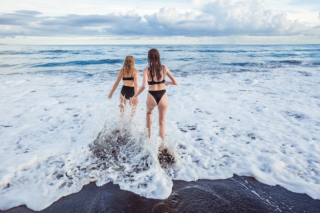 Two girls go swimming in the ocean