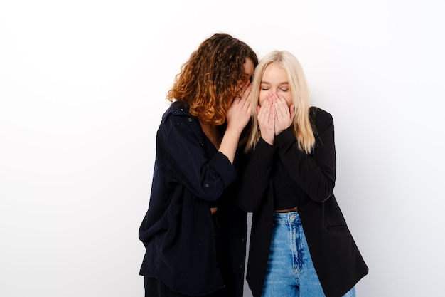 Two girls gossip and laugh