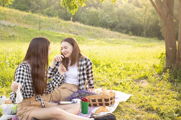 Two girls in the grass in the rays of the setting sun